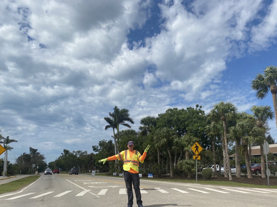 Traffic signallers such as this gentleman do their best to
      keep the traffic moving "on island."