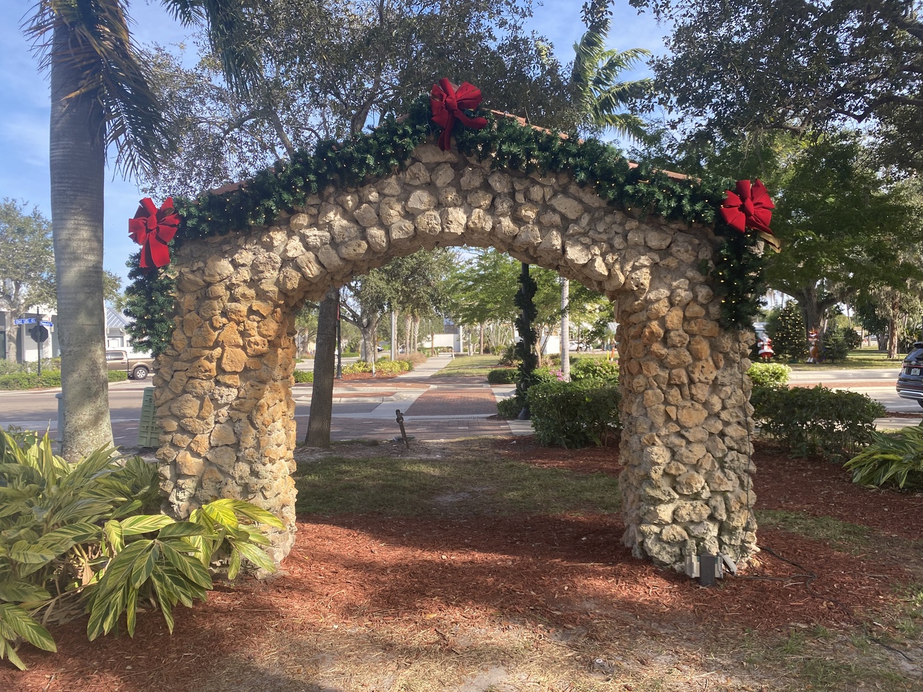 This arch is decorated with green boughs and twinkling lights
      for Christmas.