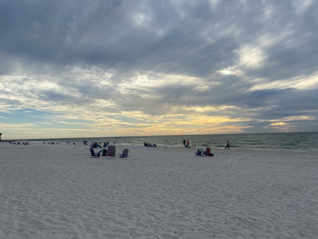 A few beachgoers are present for the sunset on December 5,
      2023.