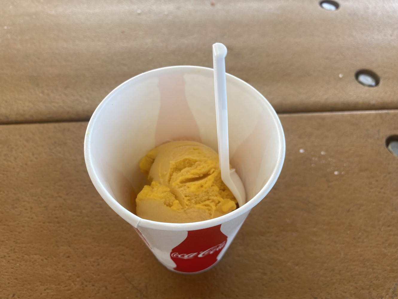 Mango gelato comes in a soda cup with a spoon.