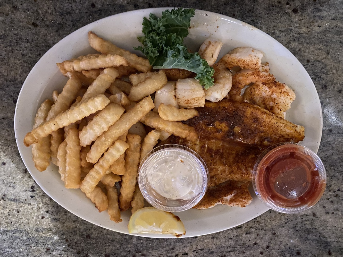 Blackened seafood platter with sauces.